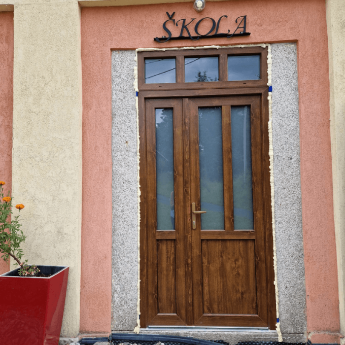 Bejárati ajtó kivitelezése felülvilágítóval és fix oldalpanellel.