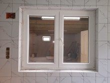 Fehér stulpos ablak egy ablakkilinccsel